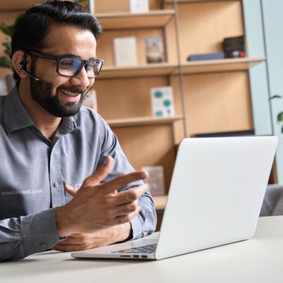 Profissional de suporte técnico da Toledo do Brasil realizando atendimento remoto por videochamada no laptop.